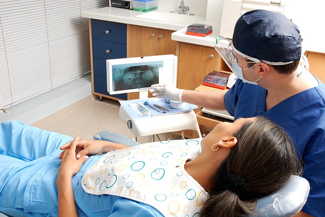 Zubař, který ukazuje na rentgenu chrup pacientky